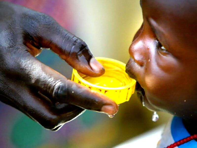 child drinking from bottle cap