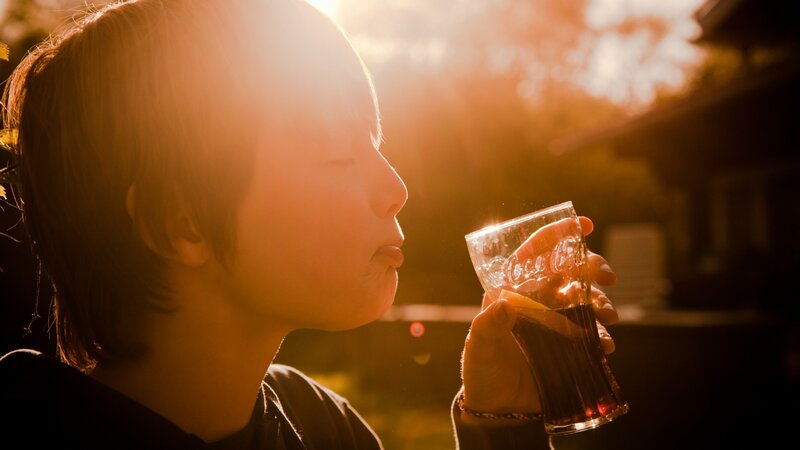 child drinking soda at sunset