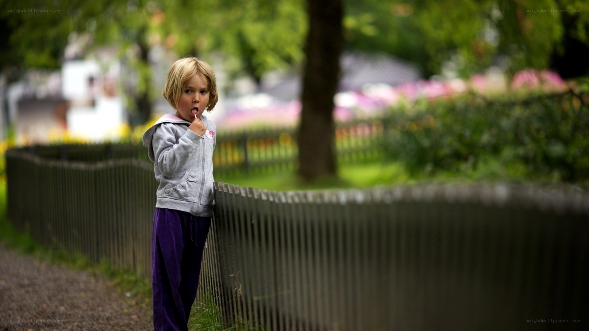 child eating lollipop in park