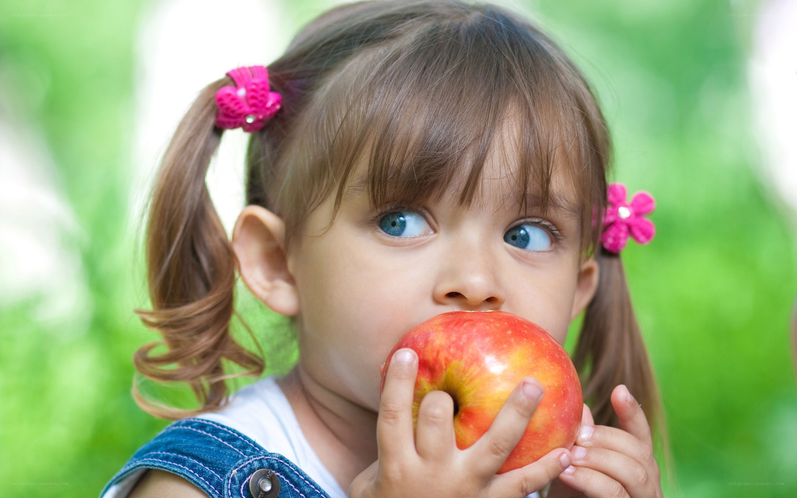 child eating red apple