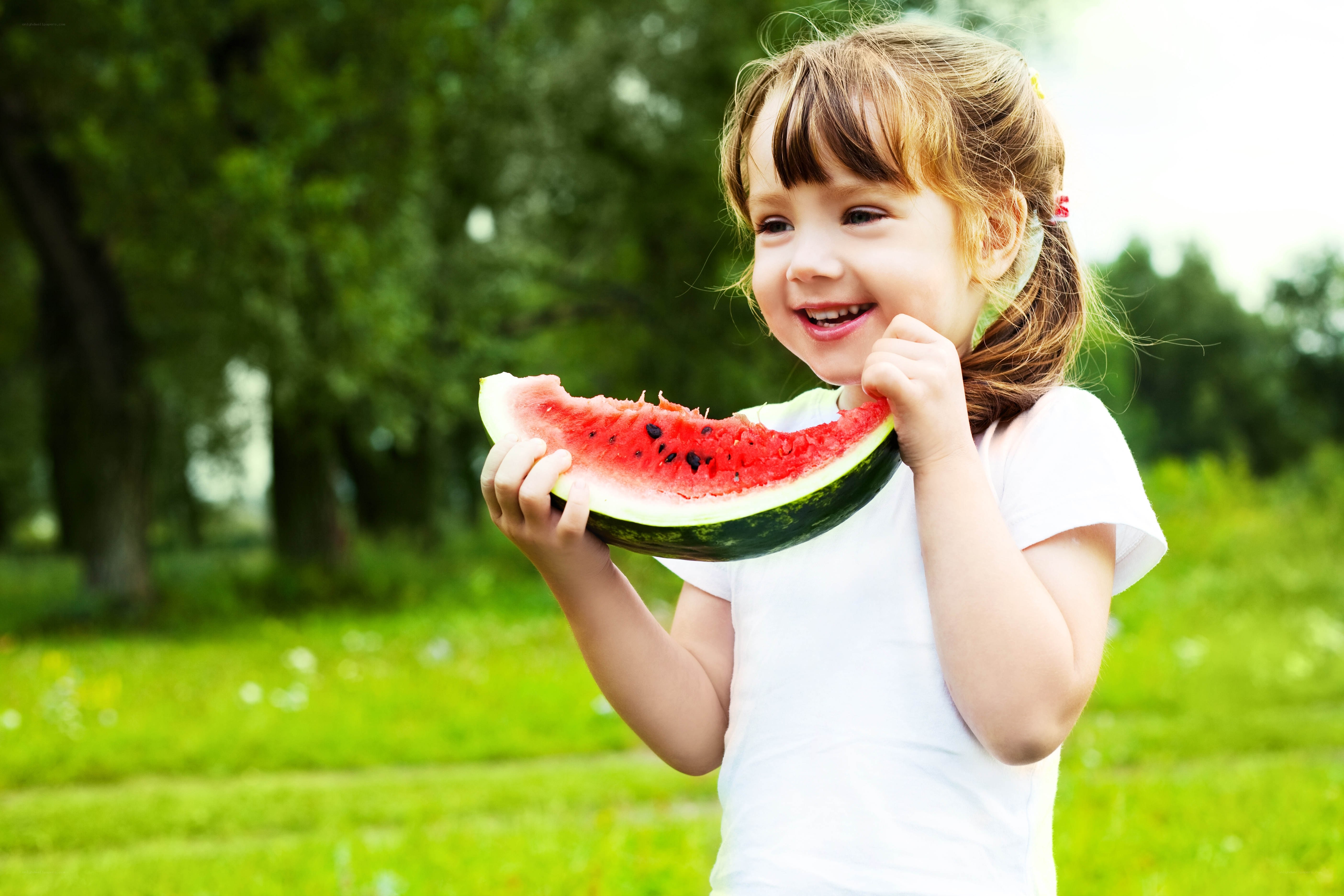 child eating watermelon outdoors