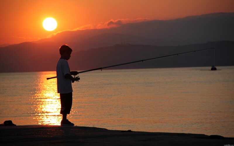 Child fishing at sunset