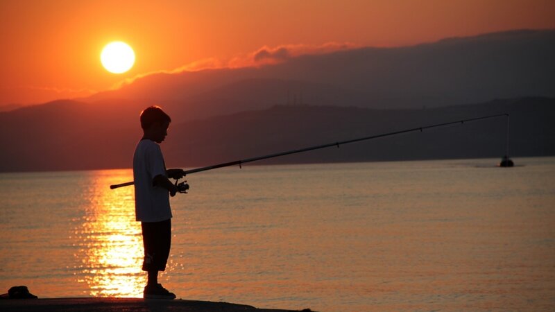 Child fishing at sunset