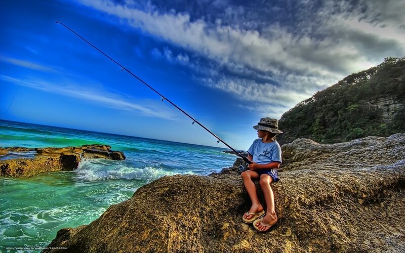 Child fishing on a rocky shore