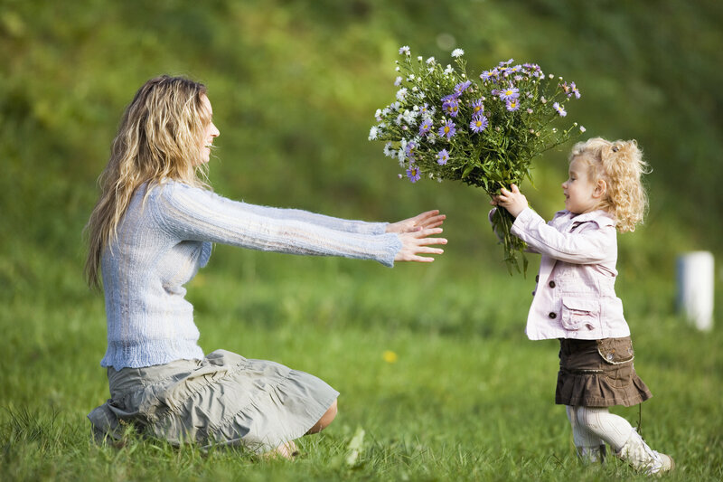 Child Giving Flowers to Woman