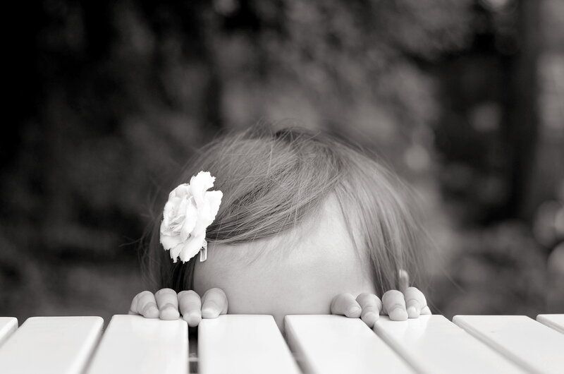 Child Hiding Behind Bench
