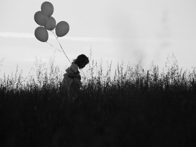 Child Holding Balloons — Black