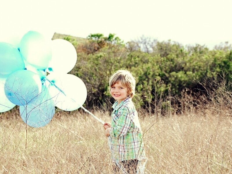 Child Holding Balloons — Blue