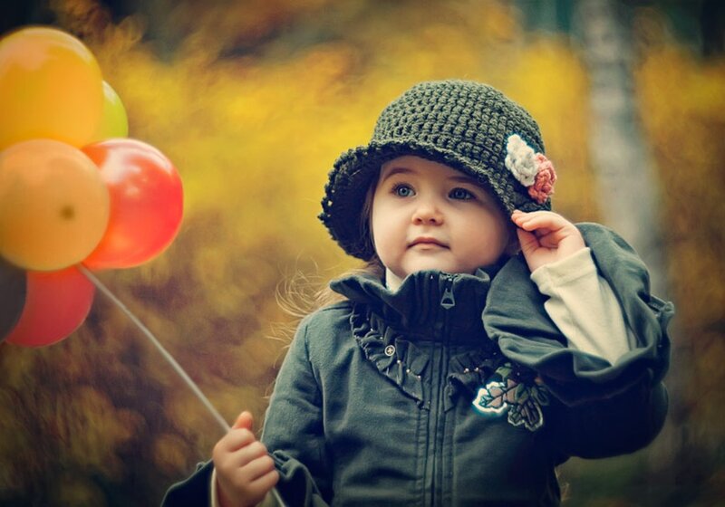 Child Holding Balloons — Green, Serene