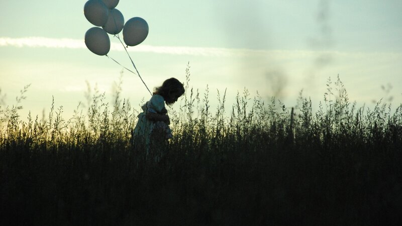 Child Holding Balloons — Green