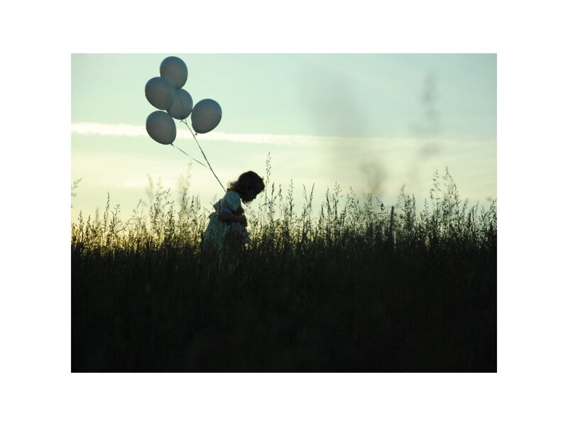 Child Holding Balloons