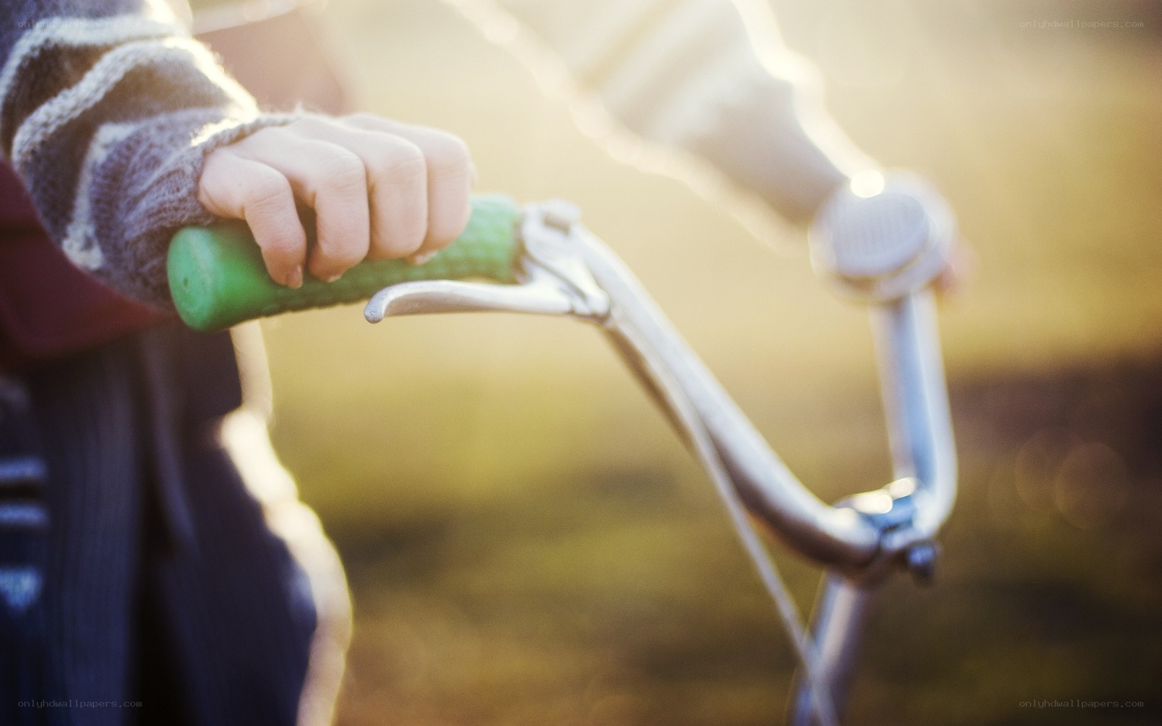 child holding bicycle handlebars