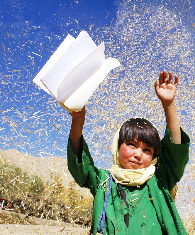 child holding book in field