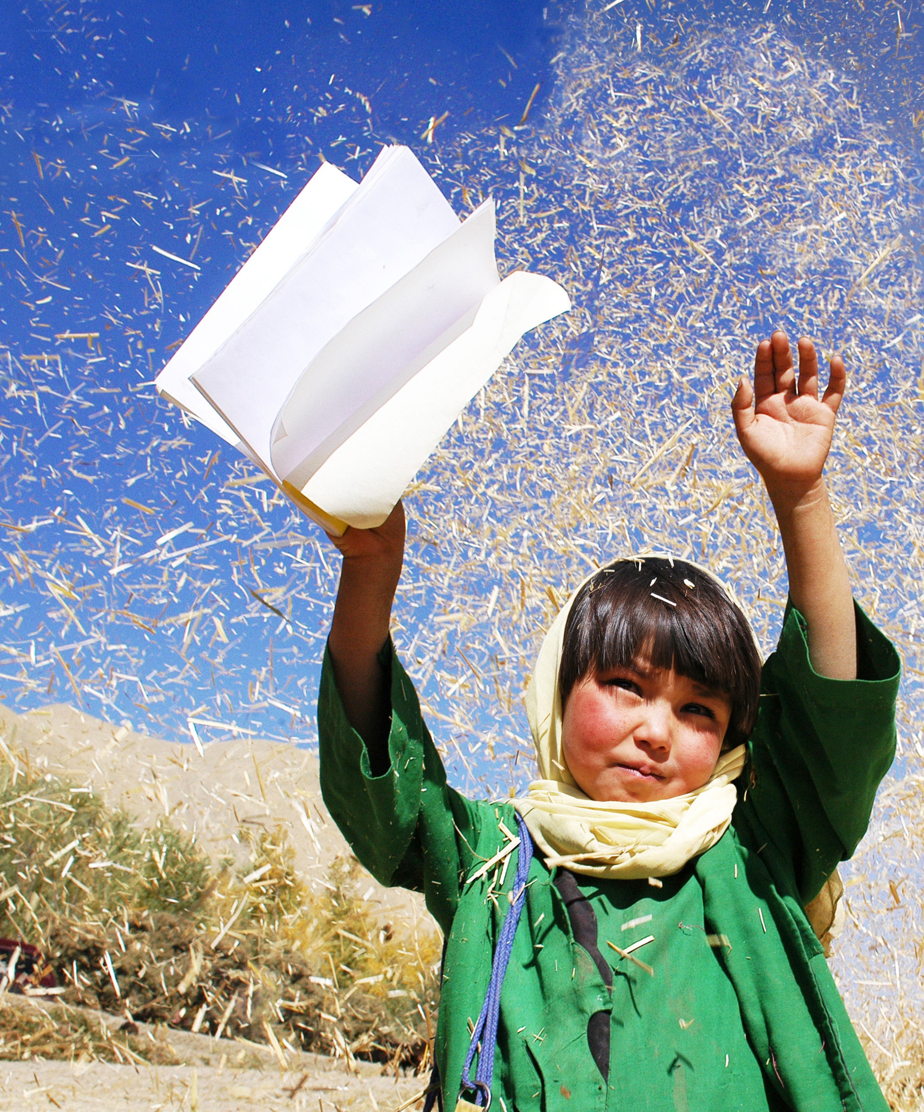 child holding book in field