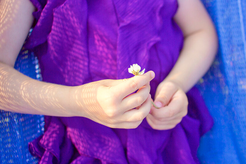 Child Holding Flower — Purple