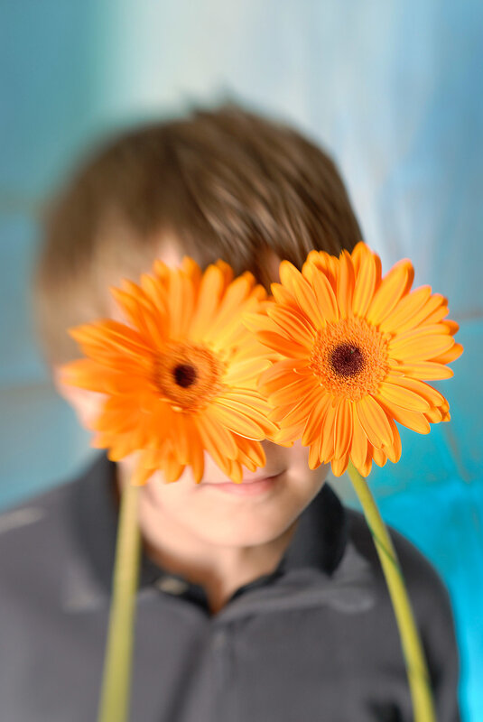 child holding flowers over face