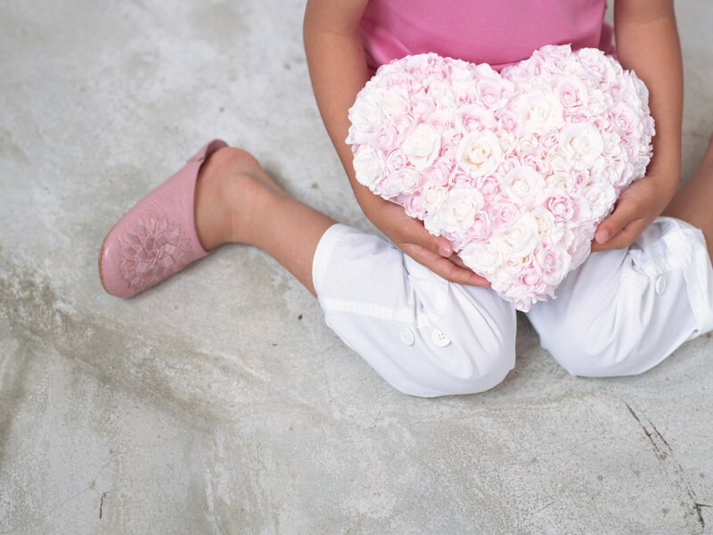 Child Holding Heart Pillow