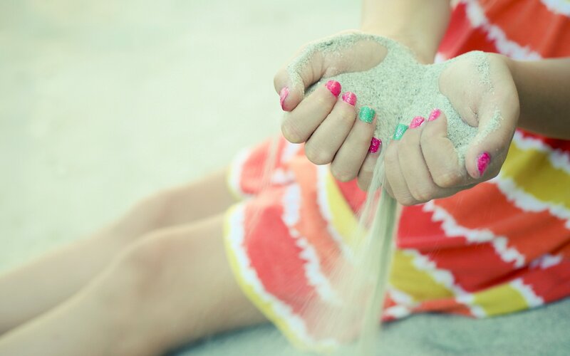 Child Holding Sand — Red