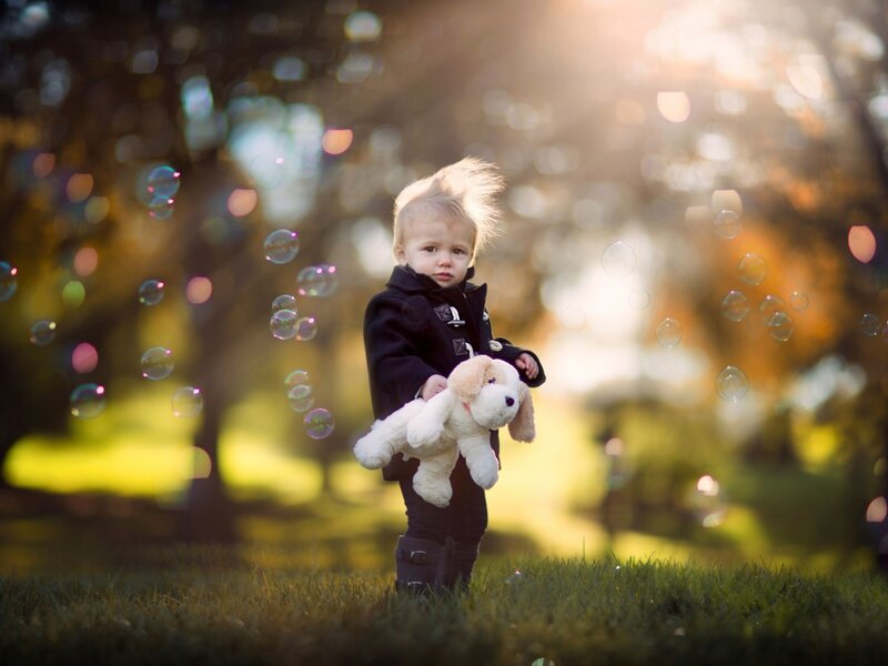 Child Holding Stuffed Dog — Green