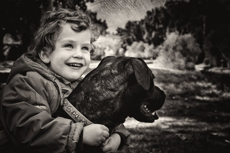 Child Hugging Dog — Black, Joyful
