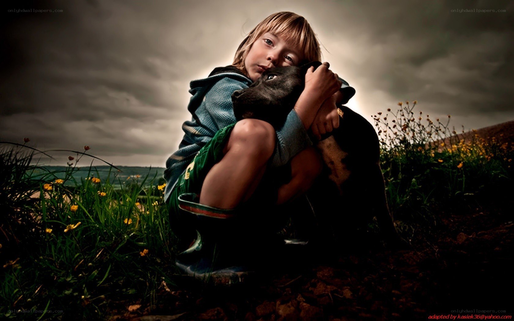 child hugging dog in field