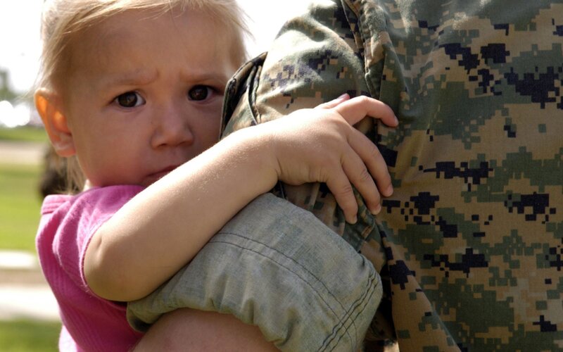 child hugging soldier
