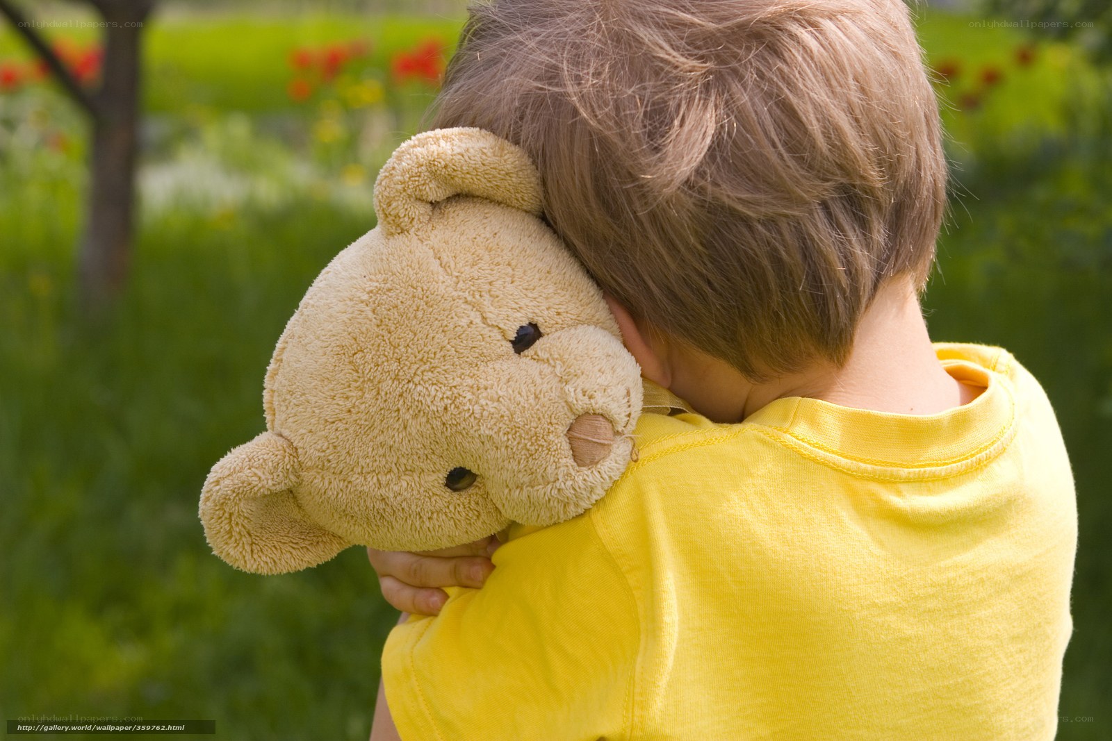 child hugging teddy bear