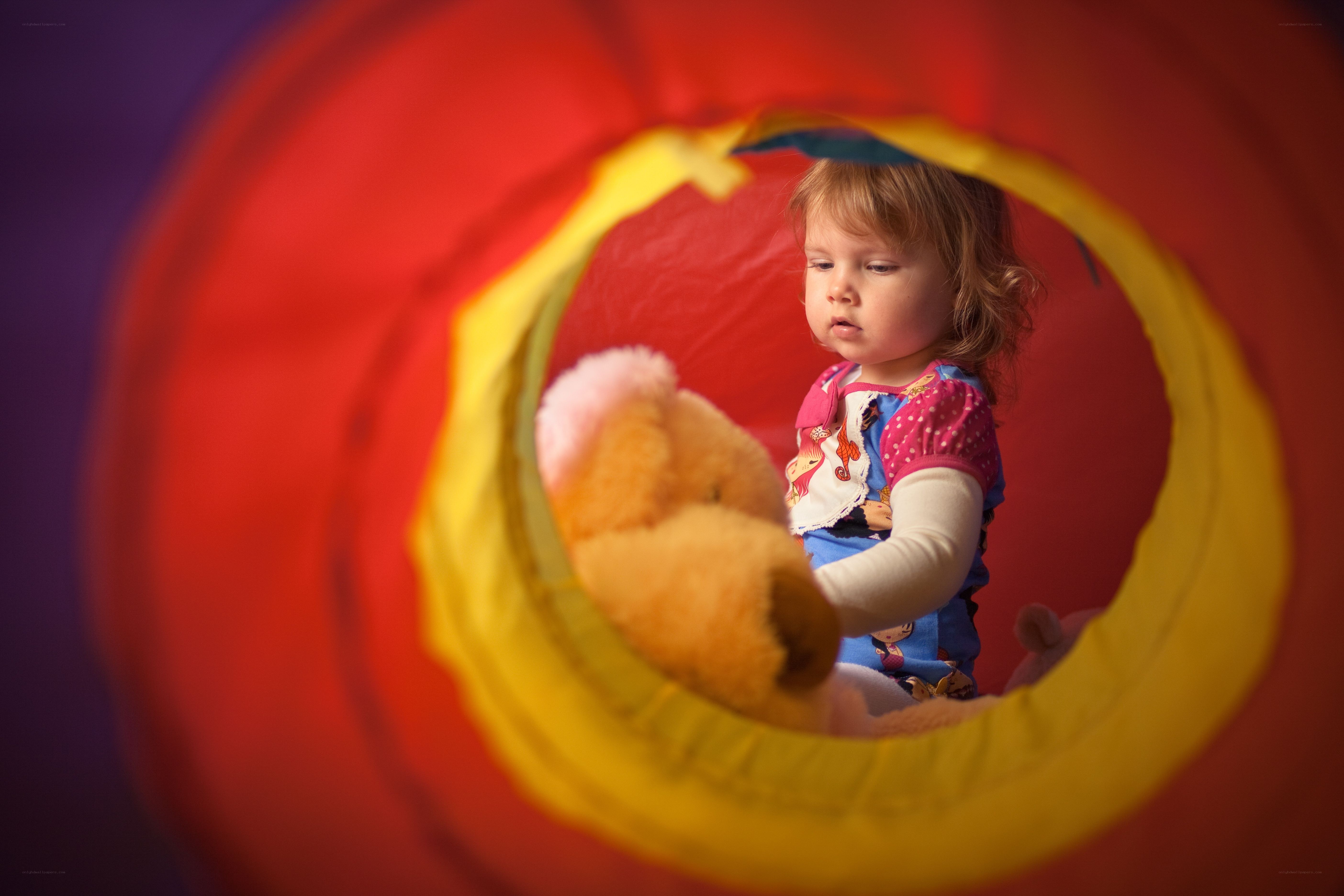 child in a play tunnel