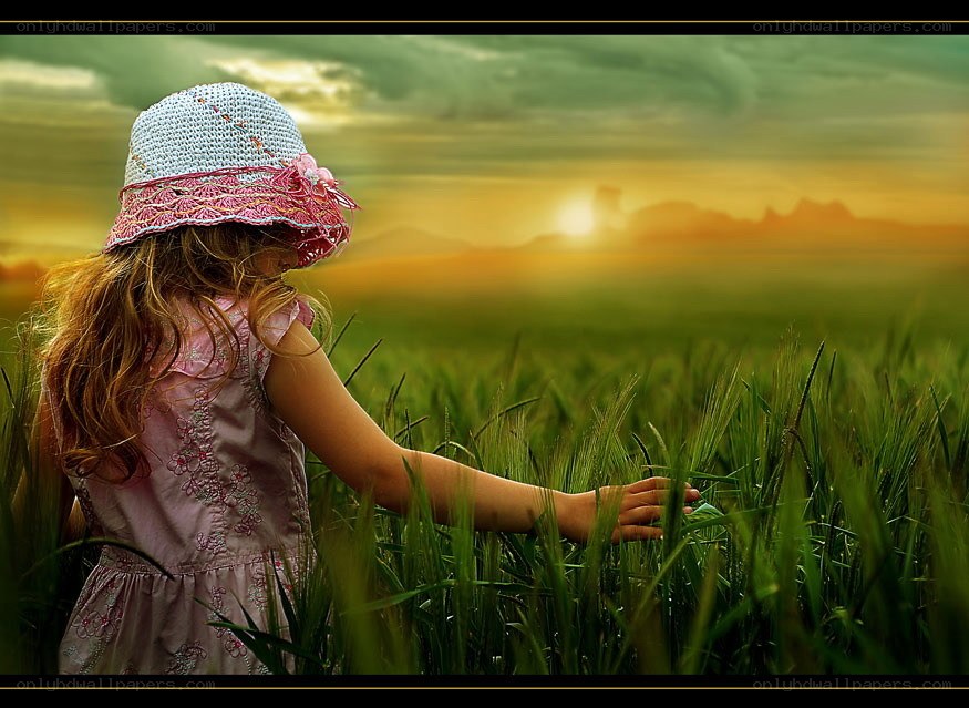Child in a wheat field at sunset
