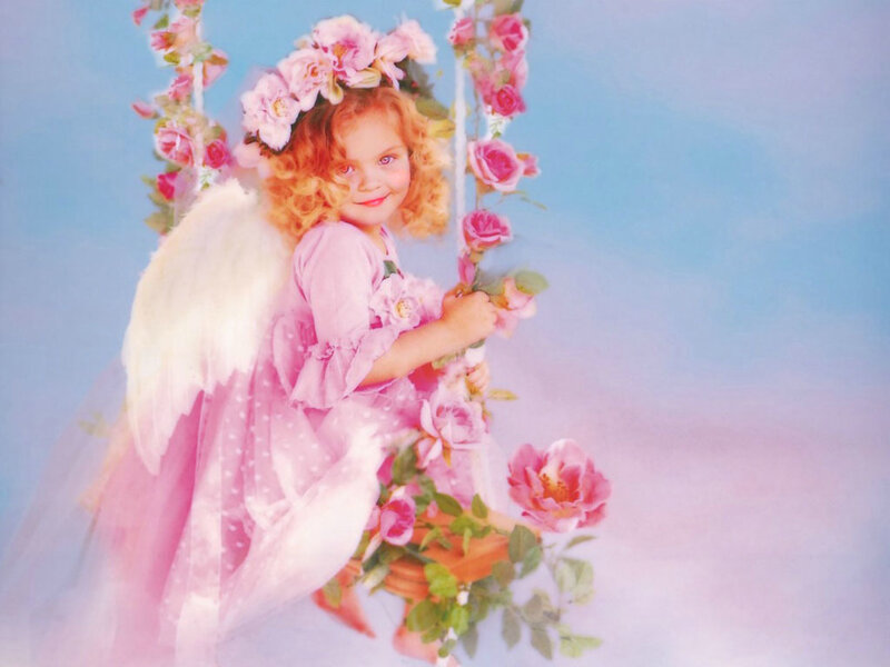 child in angel costume on swing