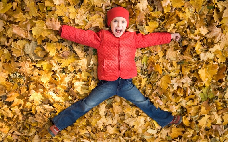 Child in Autumn Leaves — Red