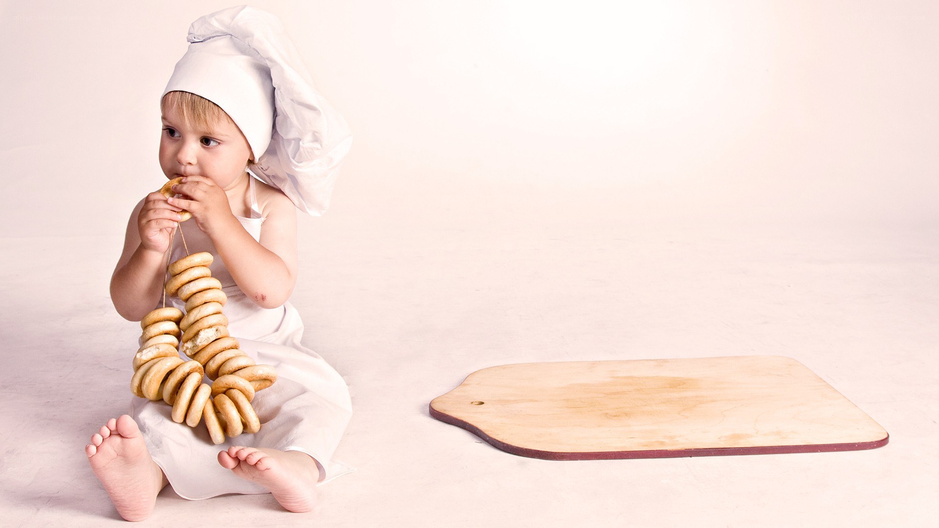 child in chef hat eating bagels