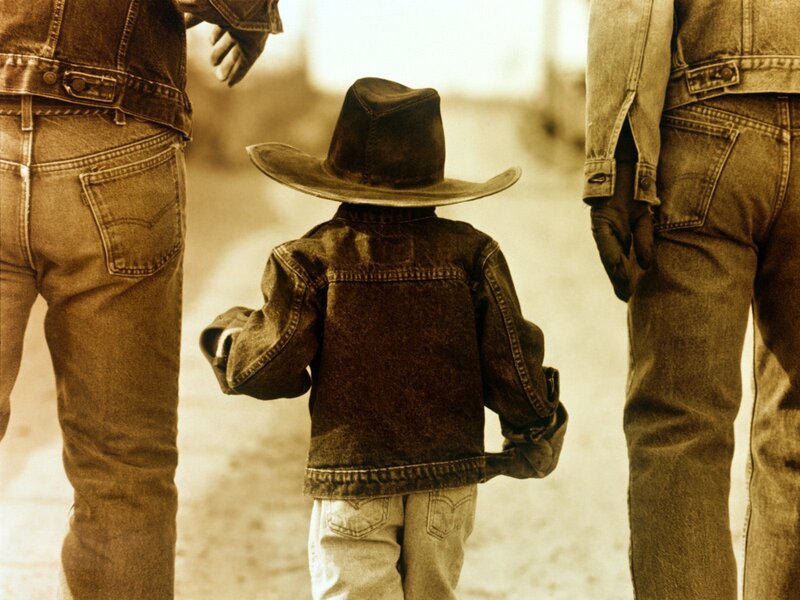 child in cowboy hat with adults