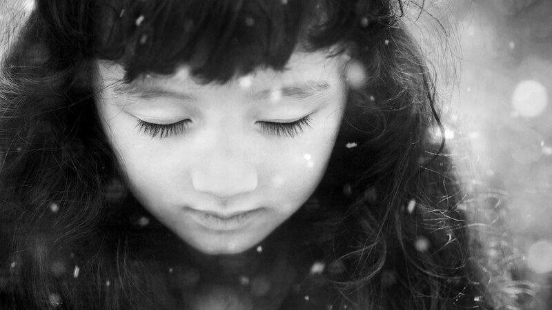 child in falling snow