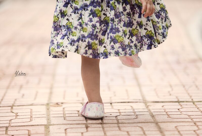 child in floral dress walking