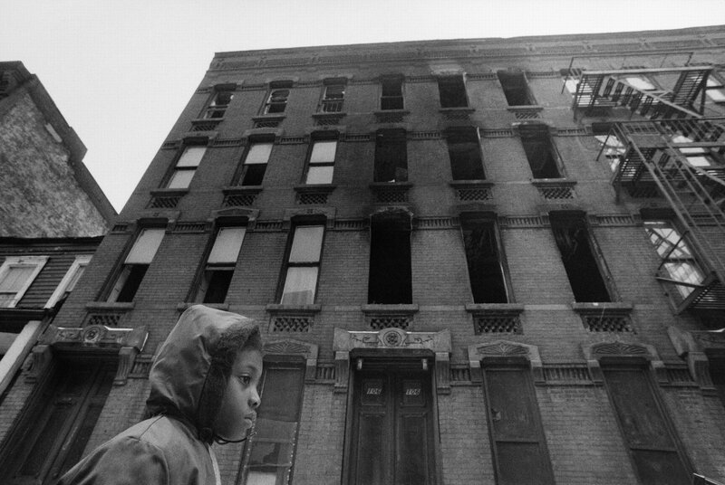 Child in front of a dilapidated building