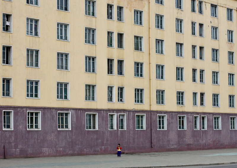 child in front of apartment building