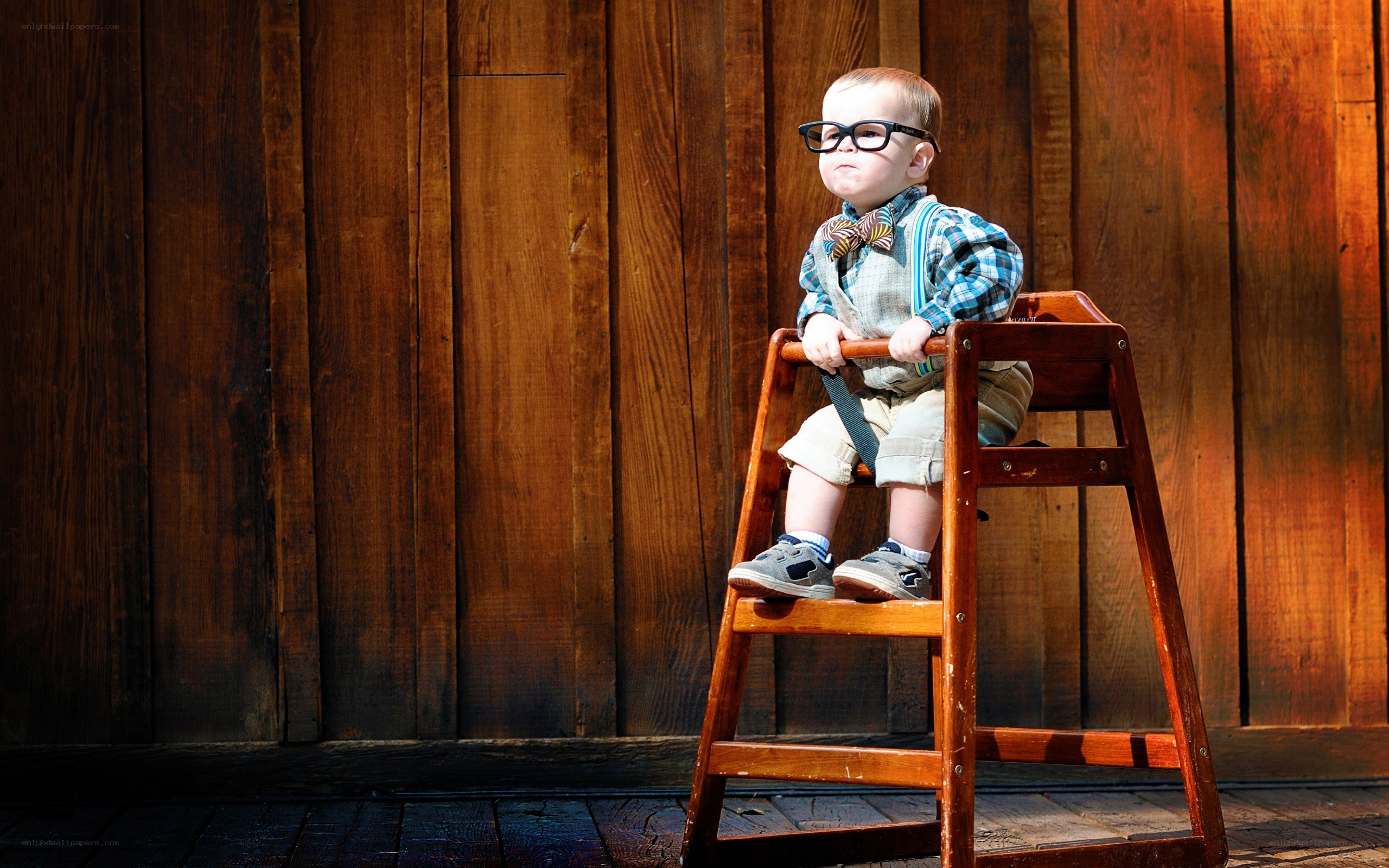 child in glasses on a stool
