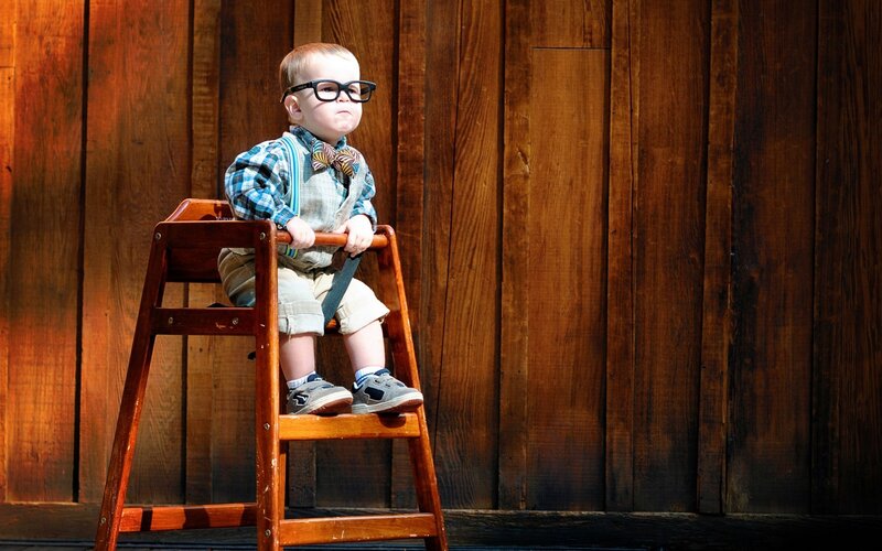 child in glasses on a stool