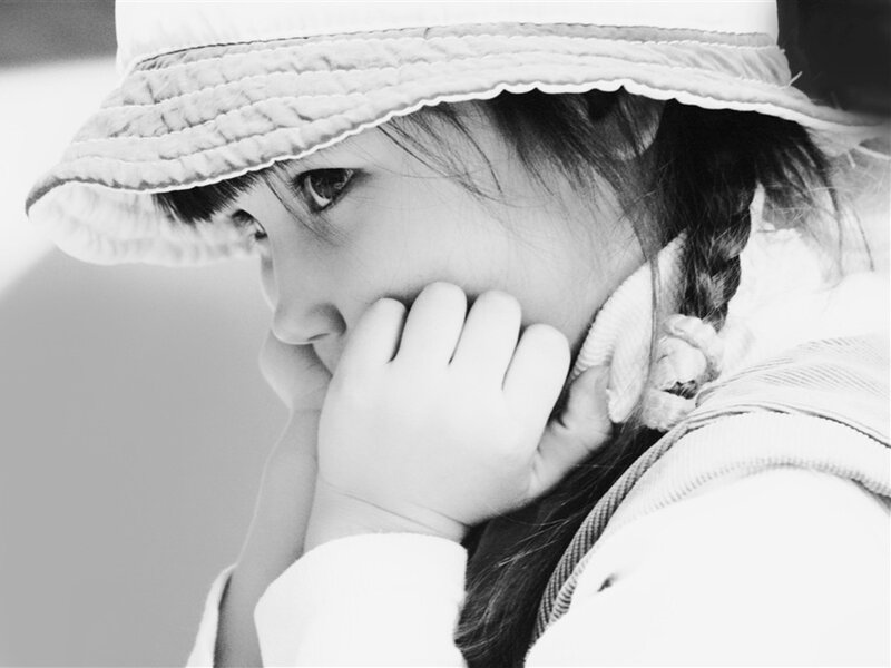 child in hat looking thoughtful
