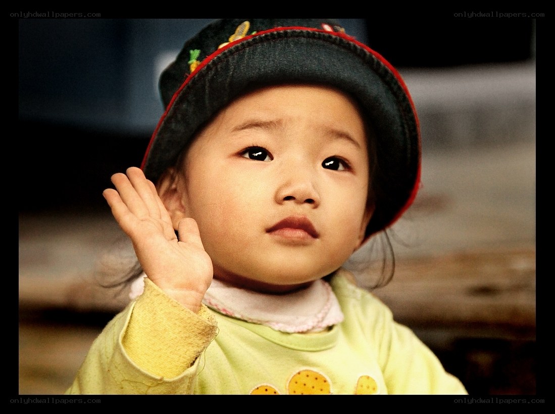 child in hat waving