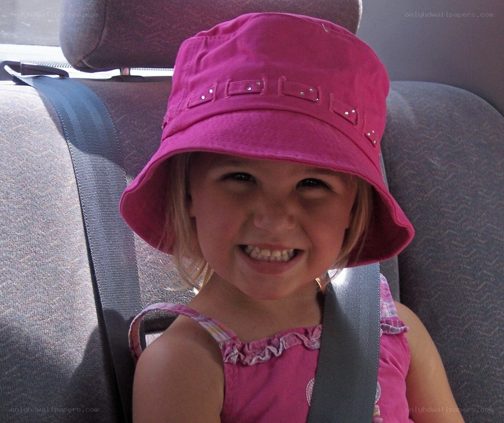 child in pink hat smiling