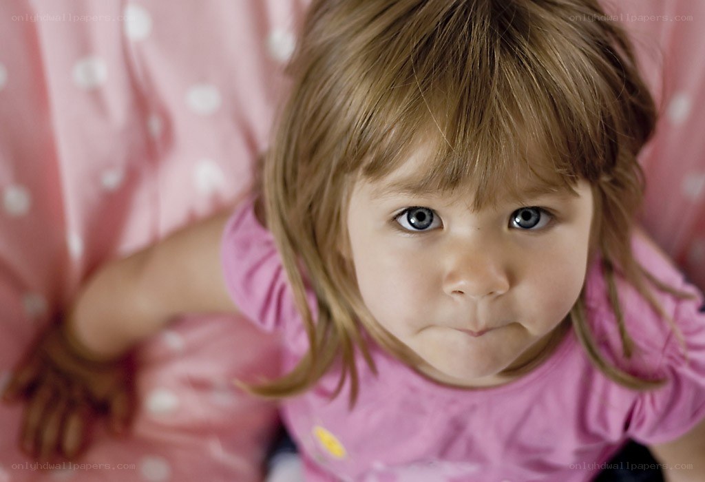 child in pink shirt looking up