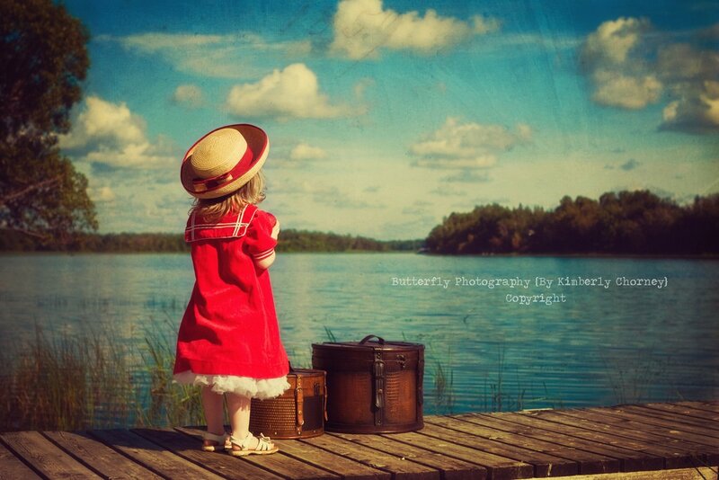 child in red dress by lake