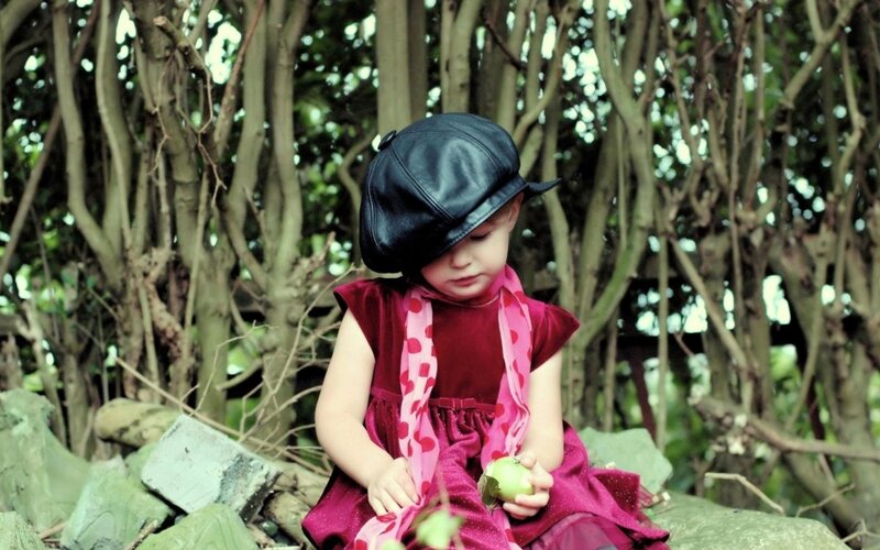 child in red dress with apple