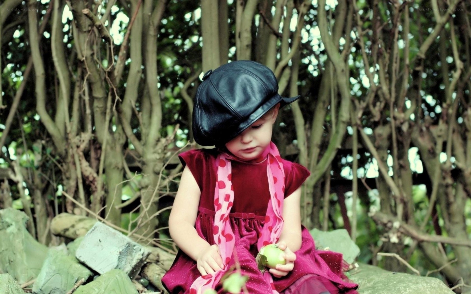 child in red dress with apple