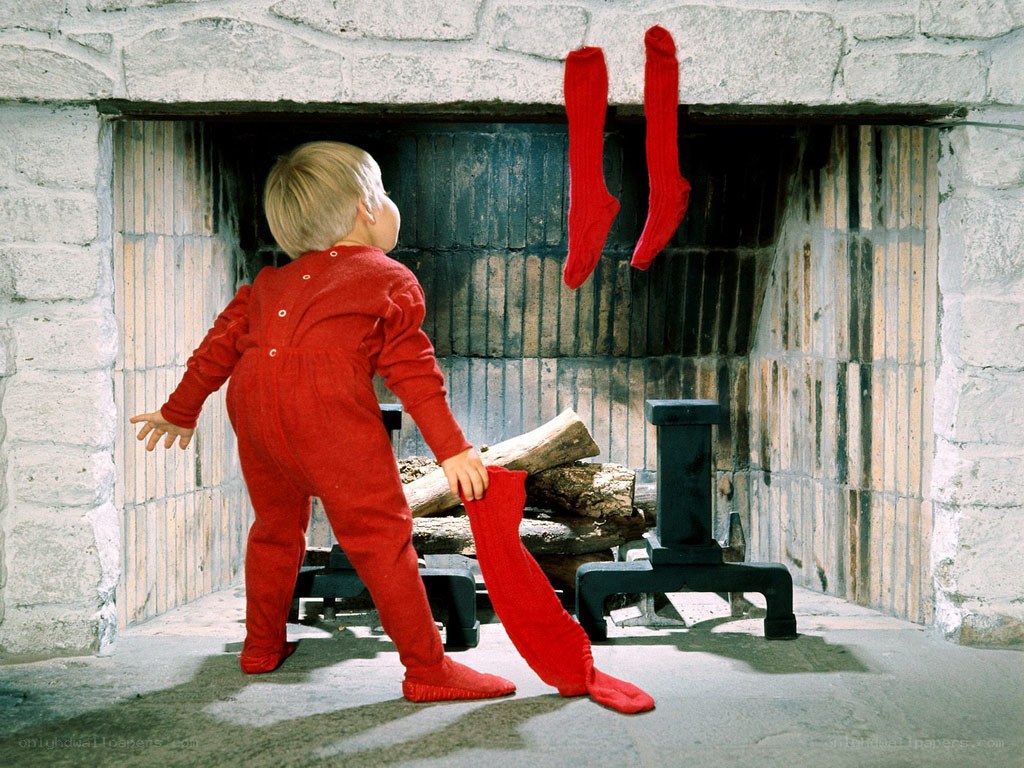 child in red pajamas by fireplace