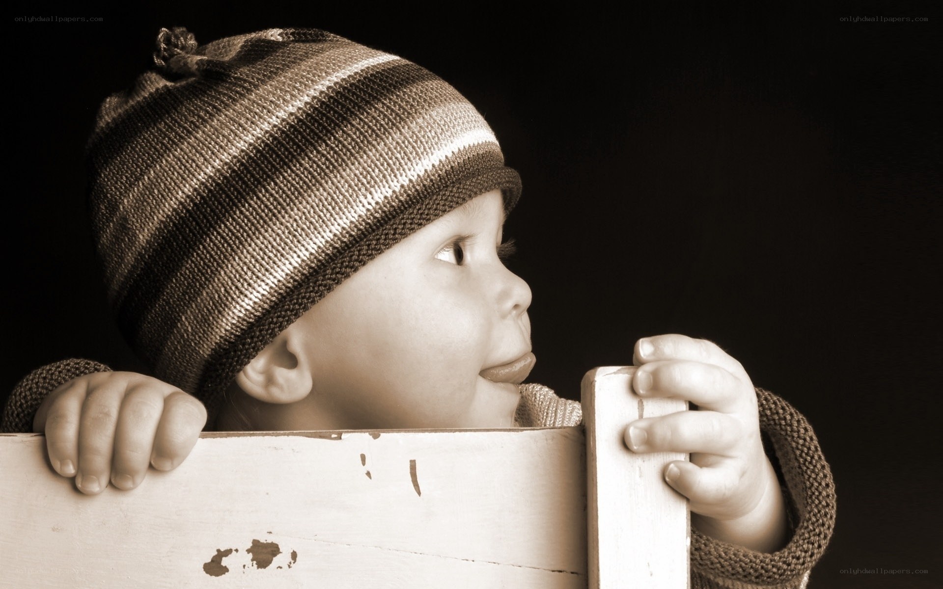 child in striped hat looking up