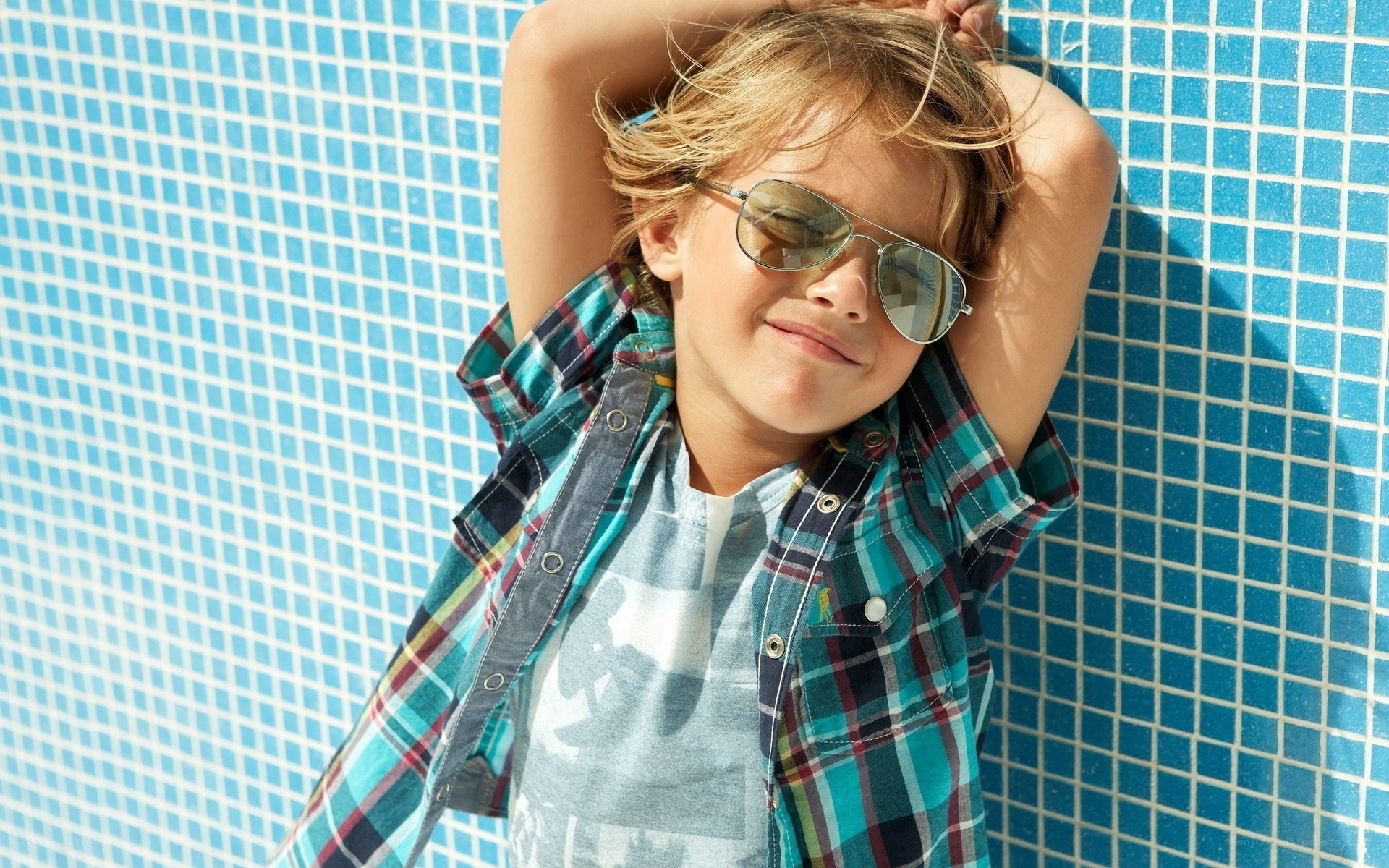 child in sunglasses by pool