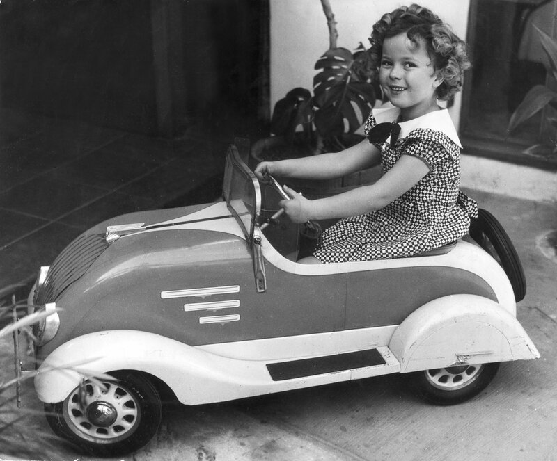 child in toy car